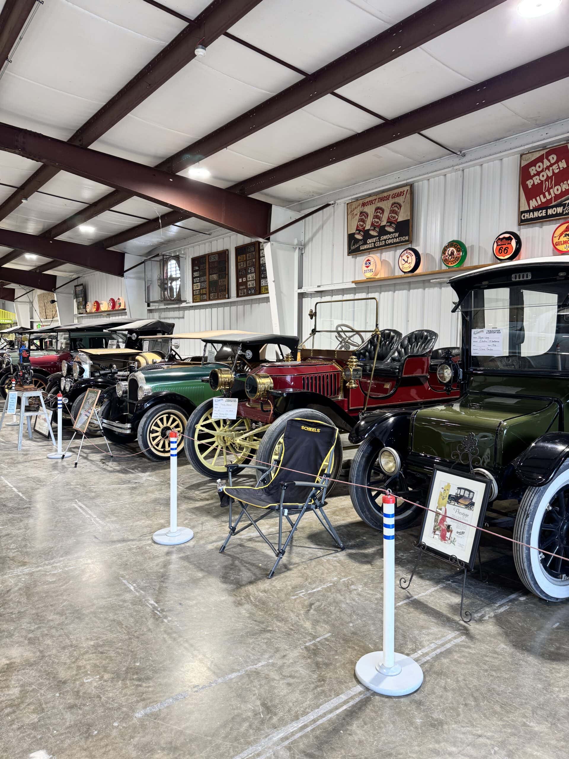Old cars on display in a warehouse building.