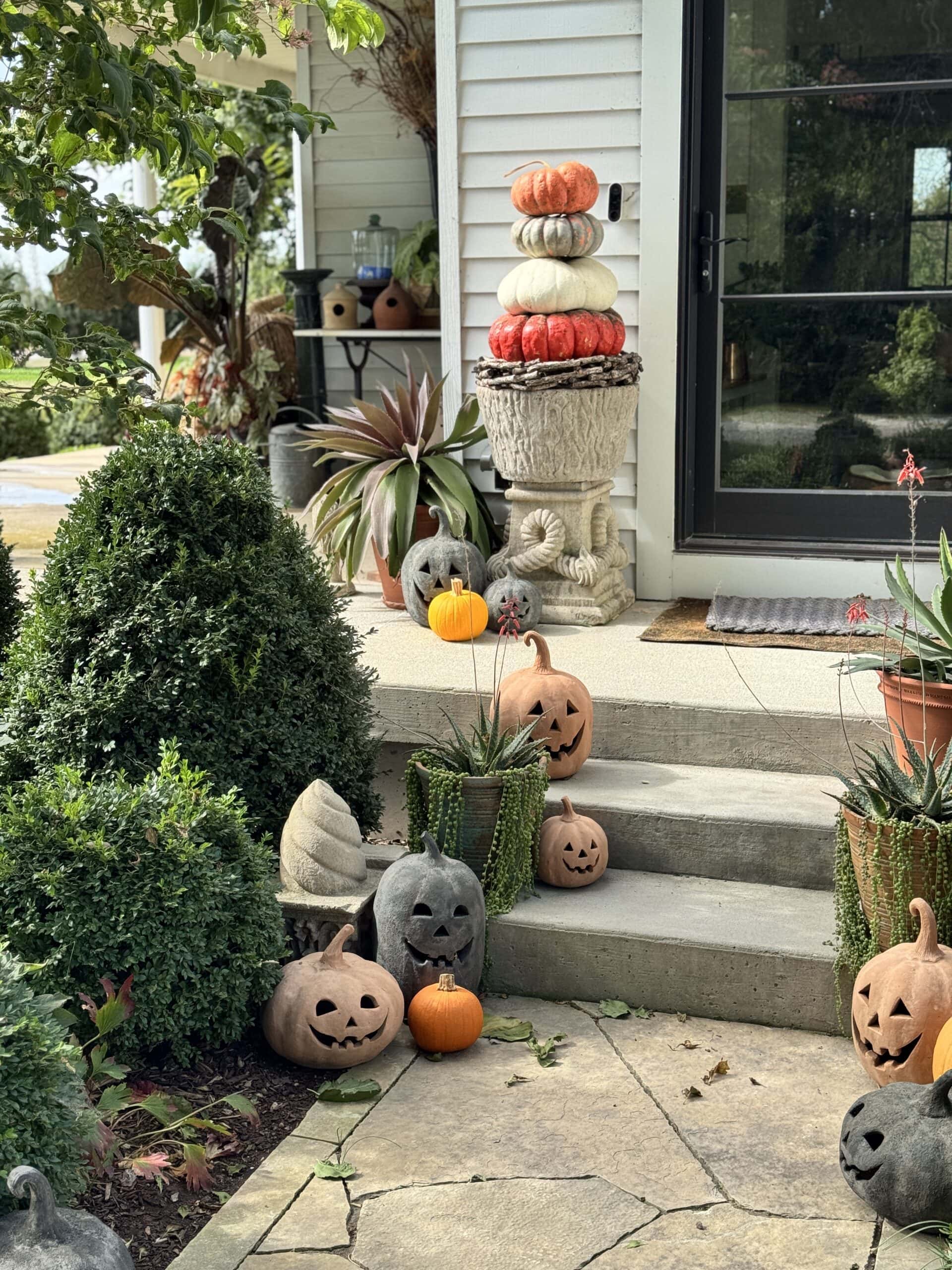 Front steps of a house adorned with pumpkins for the fall season.