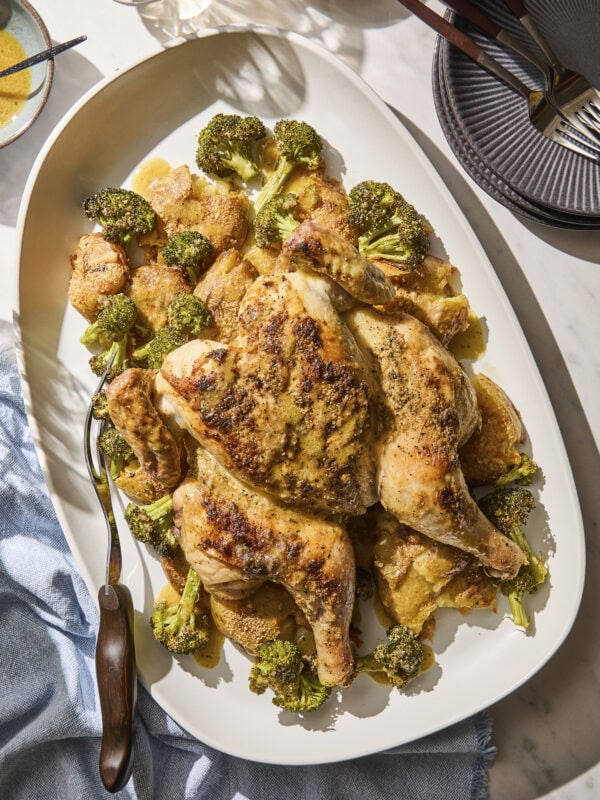 Platter with sheet pan chicken and potatoes and broccoli.