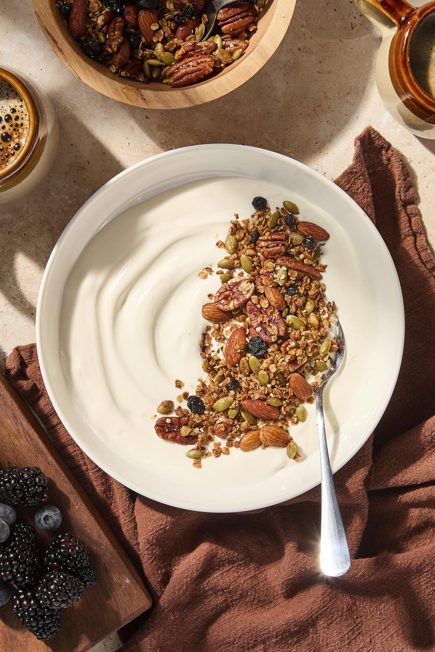 Bowl of yogurt sprinkled with granola on top.