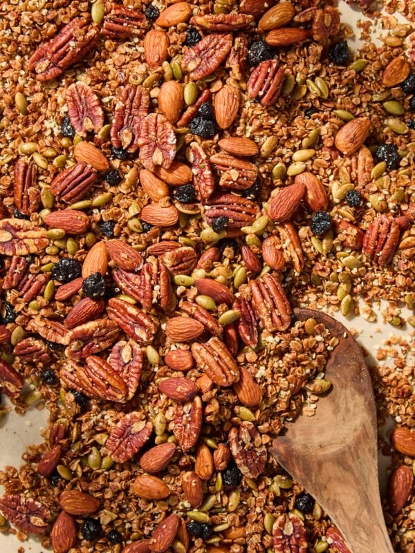 Spoon resting on homemade granola on a sheet pan.