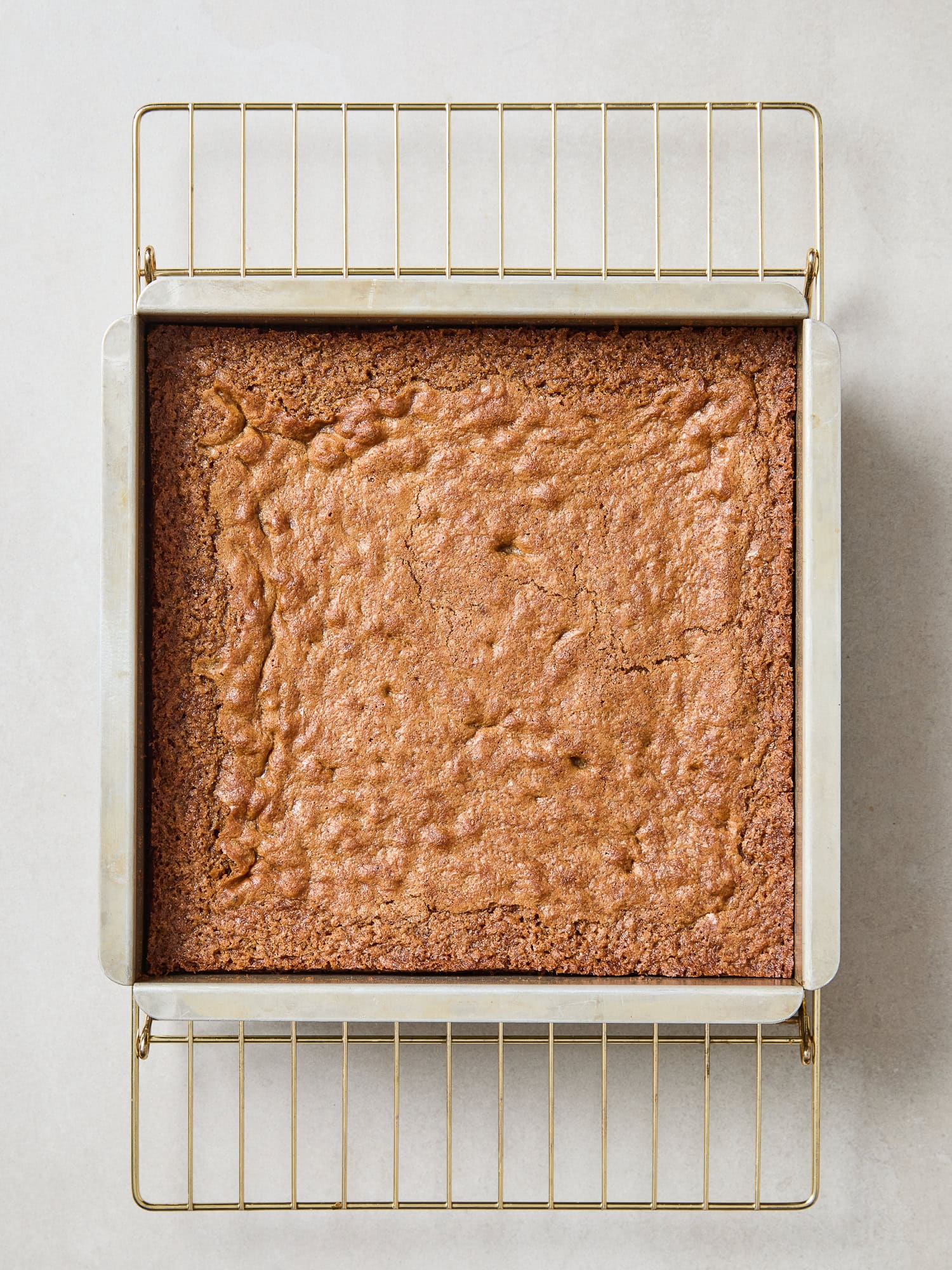 Blondies resting on a cooling rack after baking.