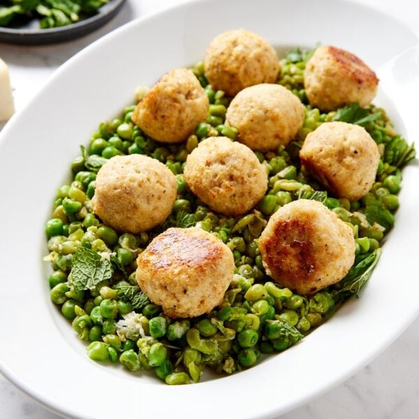 Baked chicken meatballs on a bed of pea mash.