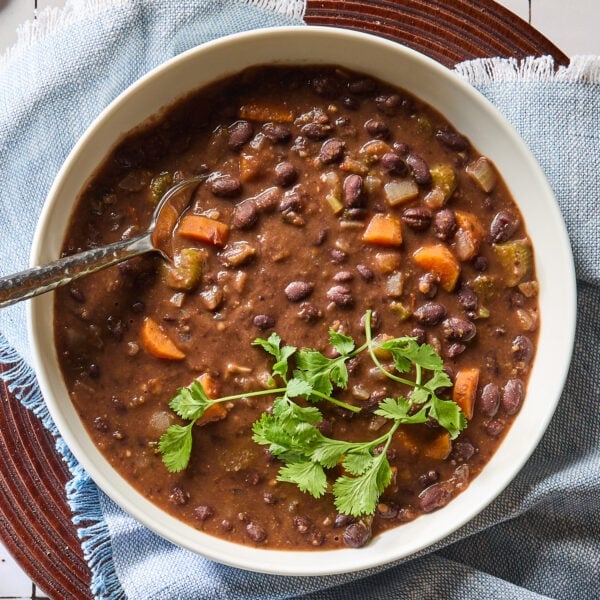 A bowl with vegetarian black bean soup topped with parsley.