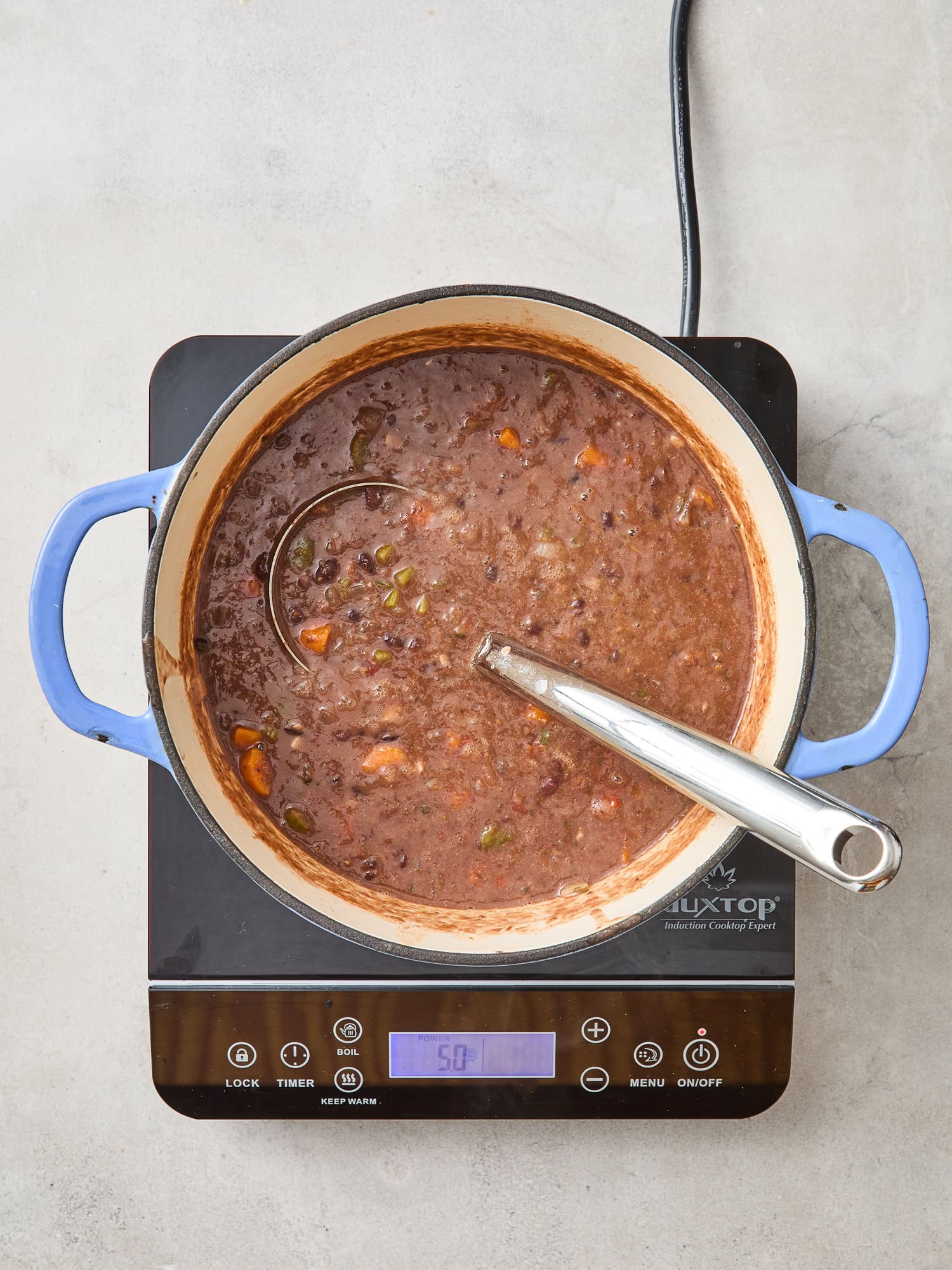 Bean soup simmering on a cooktop.