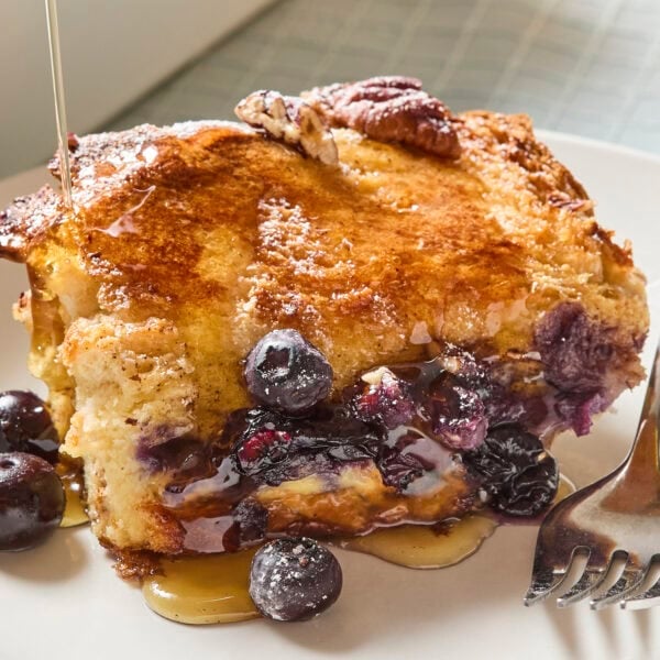 Blueberry French toast with maple syrup pouring on top.