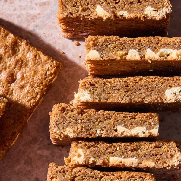 A stack of blondies lying on their side showing pieces of white chocolate inside.