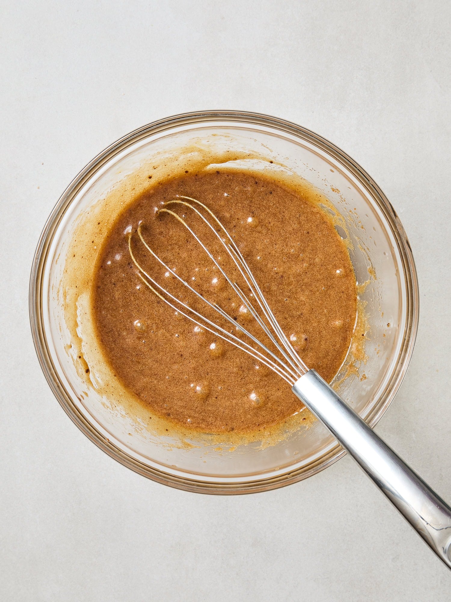Wet ingredients for brown butter blondies mixed together in a glass bowl.
