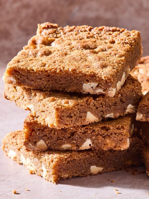 A stack of blondies with white chocolate chips.