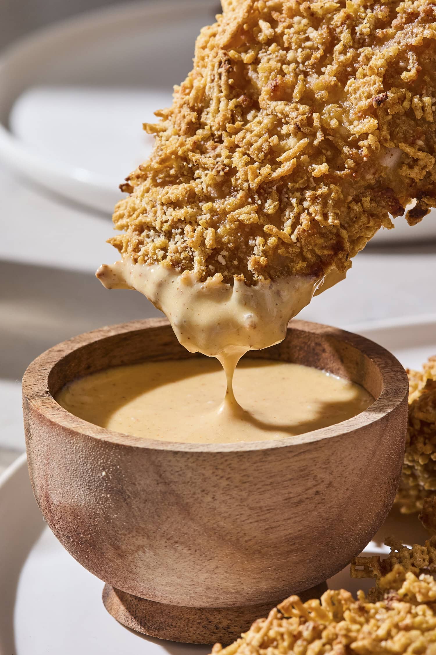 Dipping a chicken strip into honey mustard sauce.