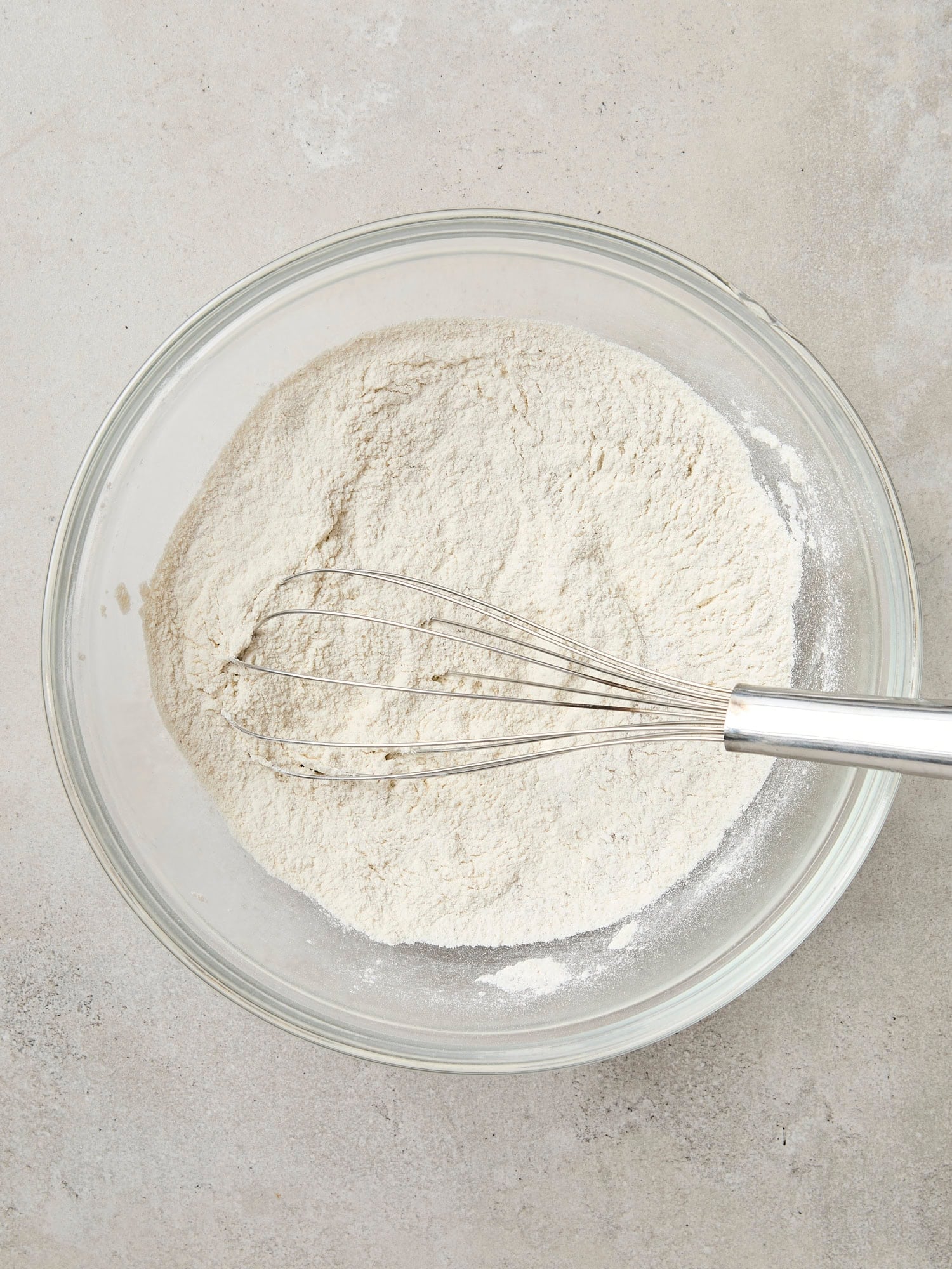 Dry ingredients in glass bowl for pancakes.
