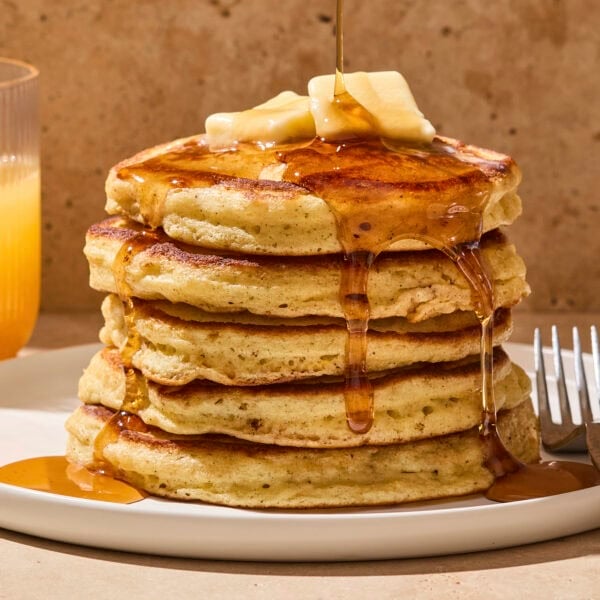 Stack of buttermilk pancakes with butter and syrup.