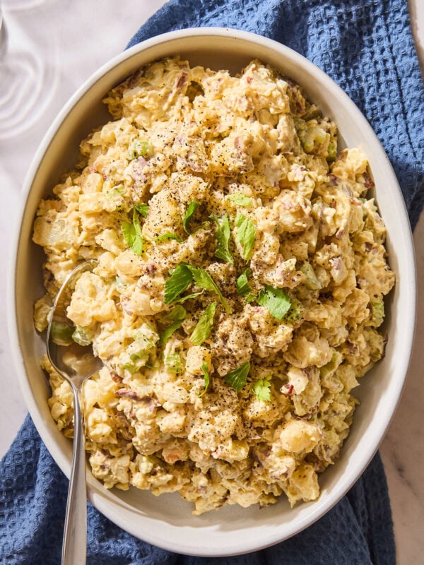 Potato salad in a large serving dish sitting on a towel.