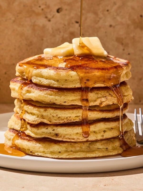 Stack of buttermilk pancakes on a plate with syrup.