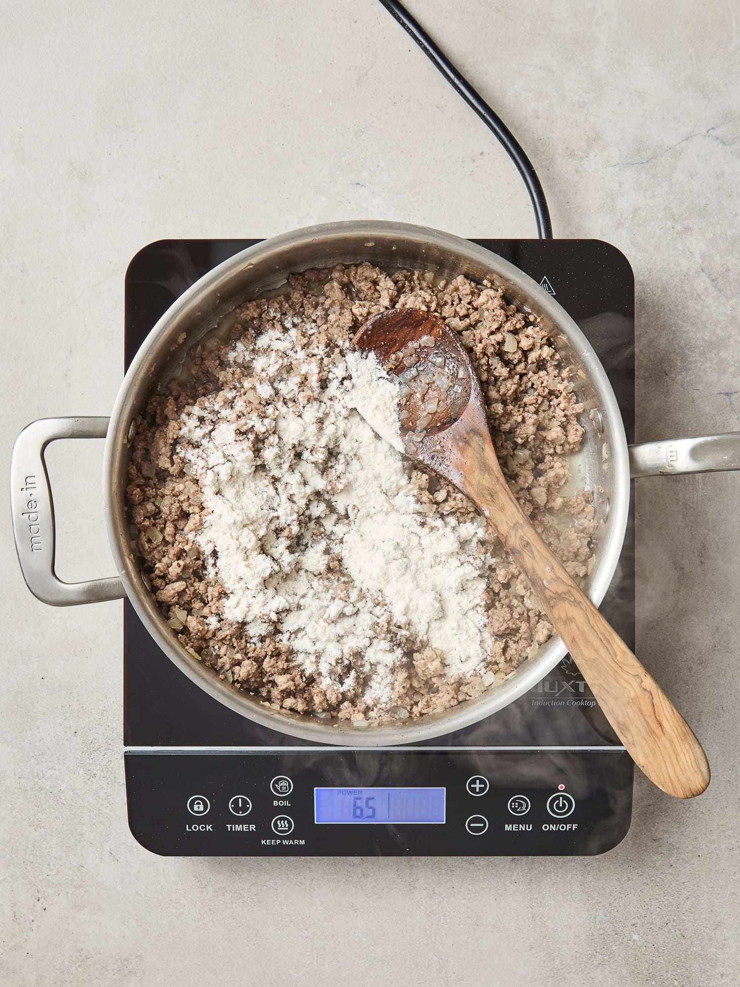 Flour added to a ground meat mixture cooks down.