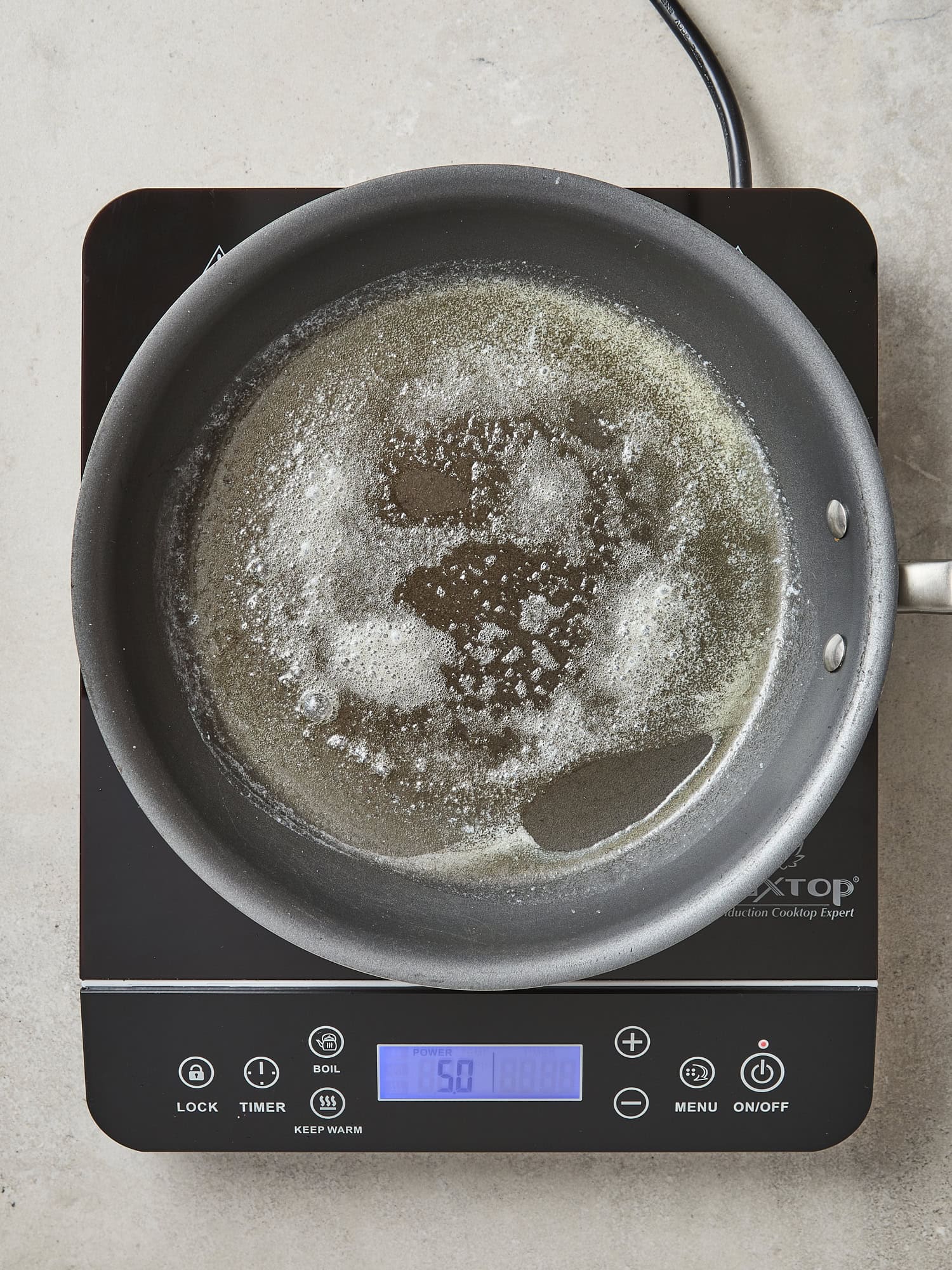 Butter heating in pan for cooking pancakes.