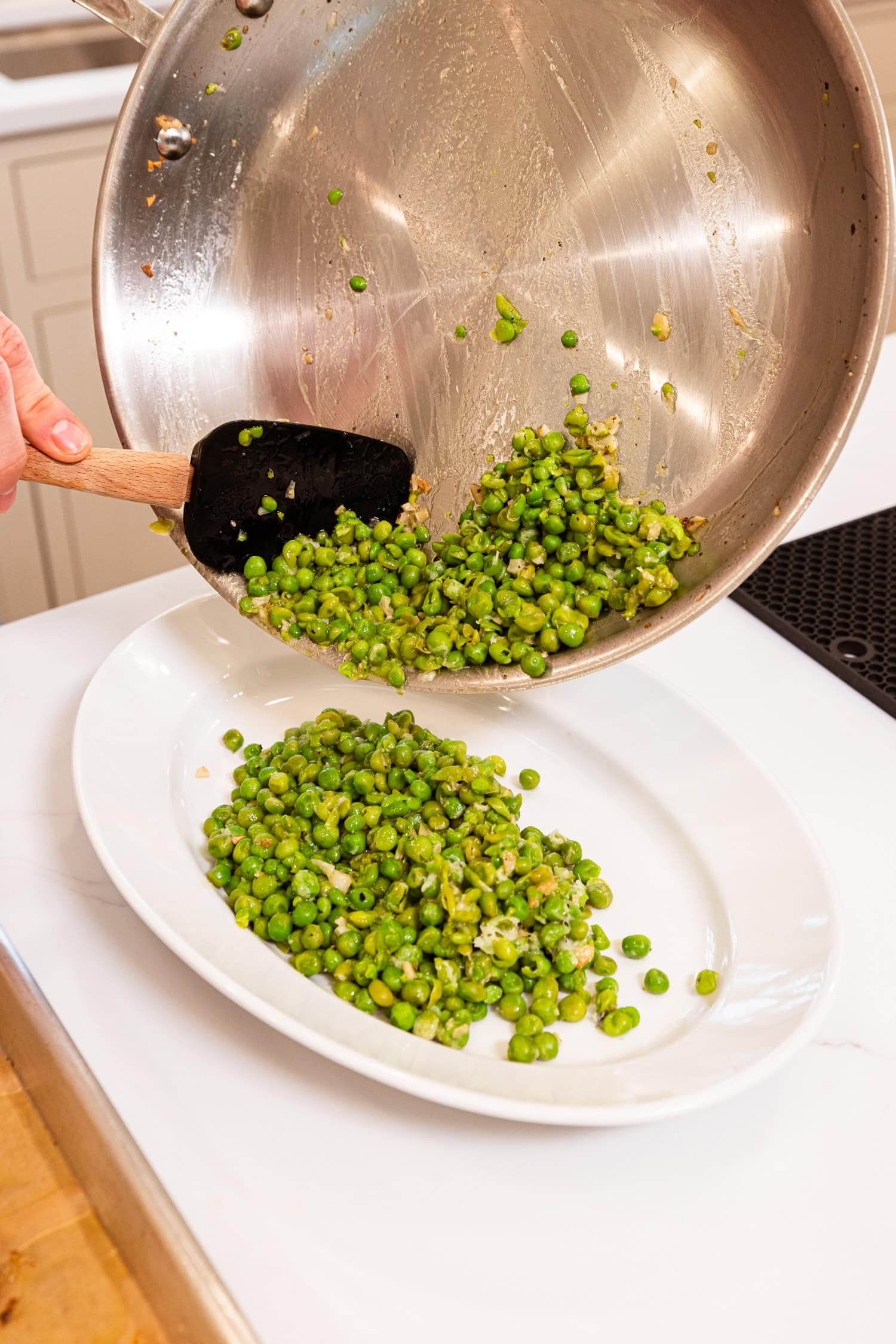 Plating the pea mash to go under baked chicken meatballs.