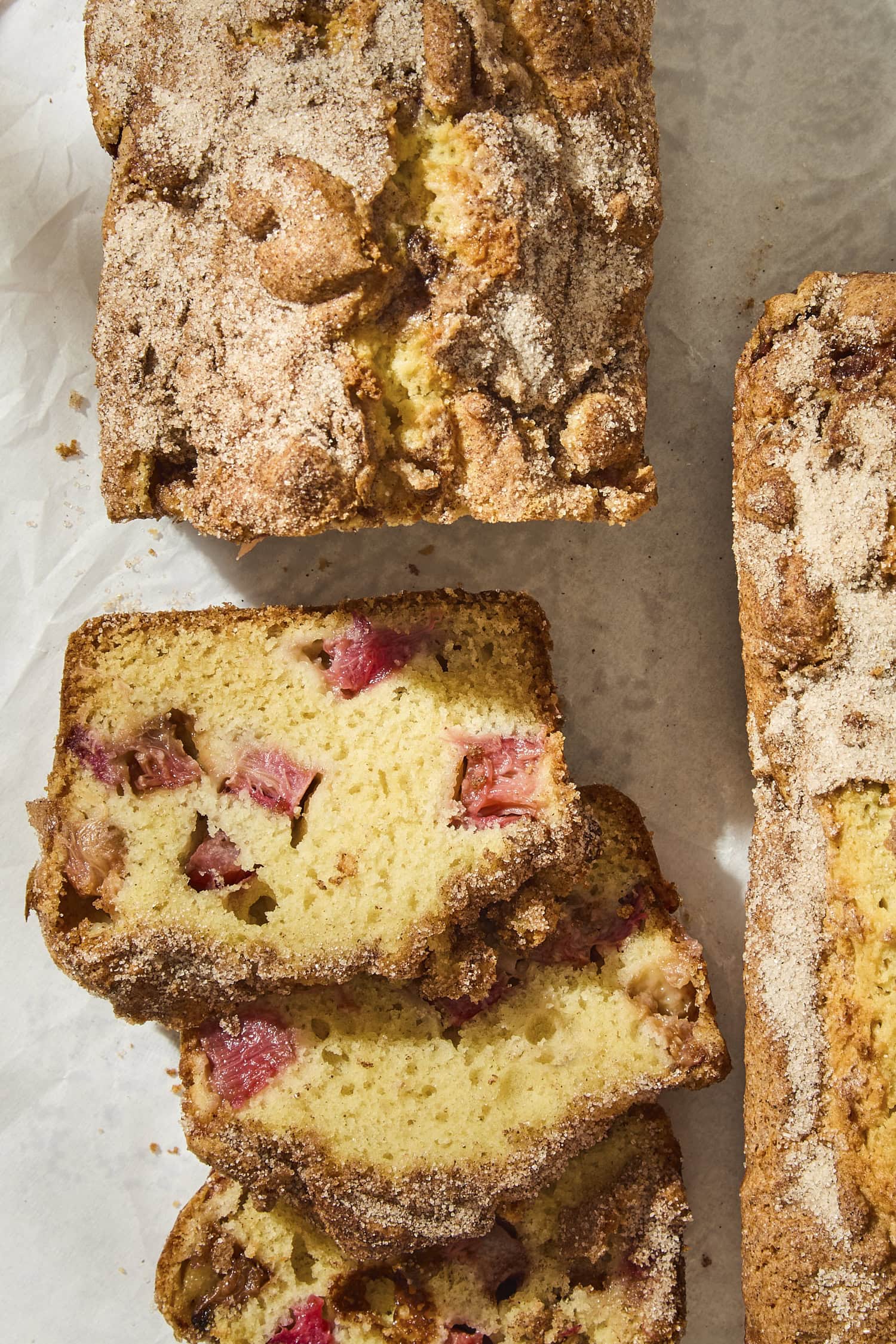 Slices of rhubarb buttermilk cake with pieces of rhubarb showing.
