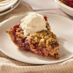 Piece of rhubarb pie with ice cream on top.