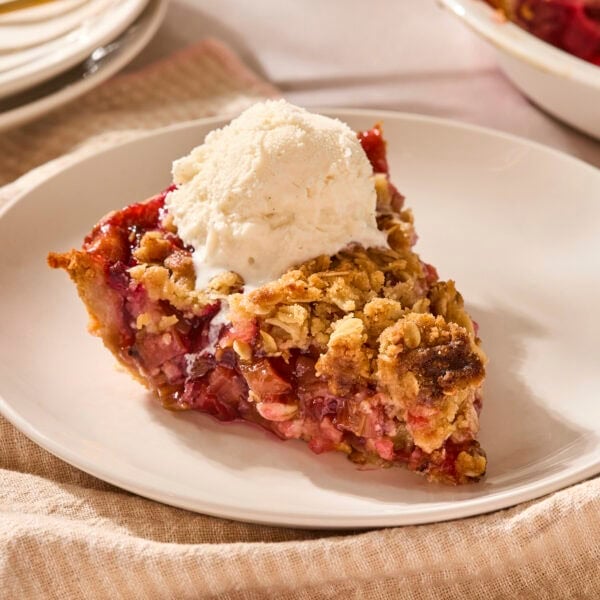 Piece of rhubarb pie with ice cream on top.
