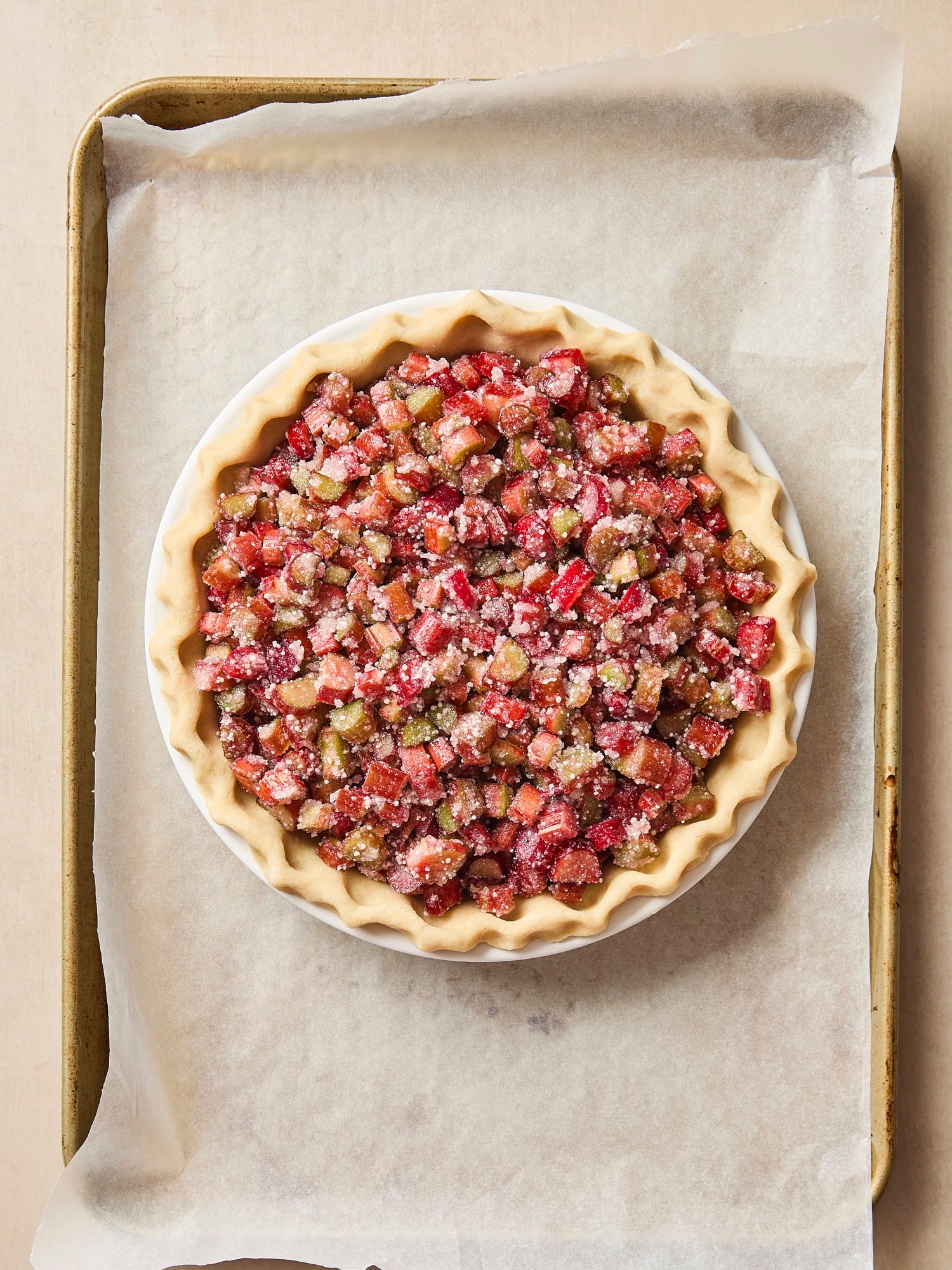 Rhubarb pie on a baking sheet before being baked.