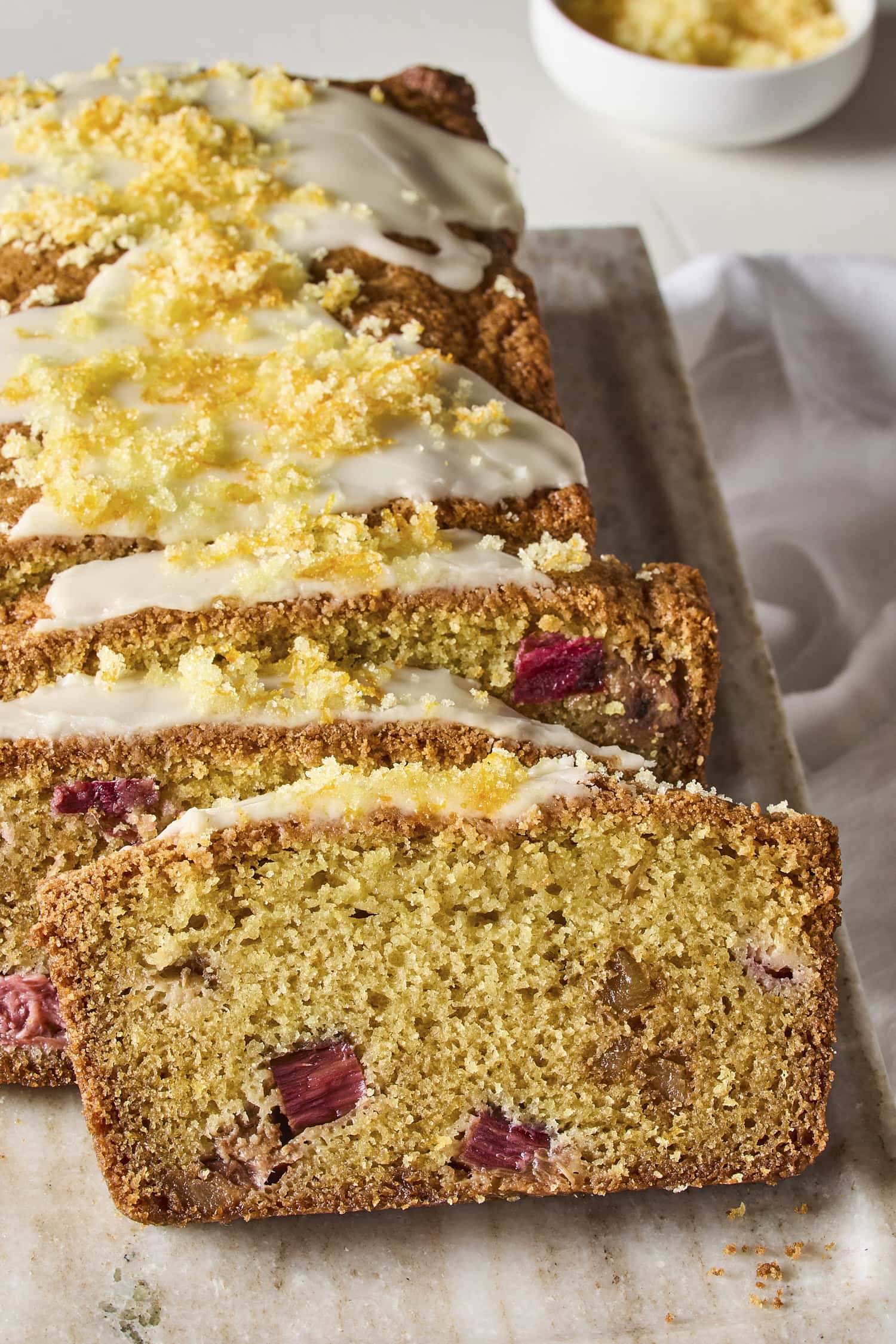 Slices of rhubarb pound cake with glaze and orange zest.