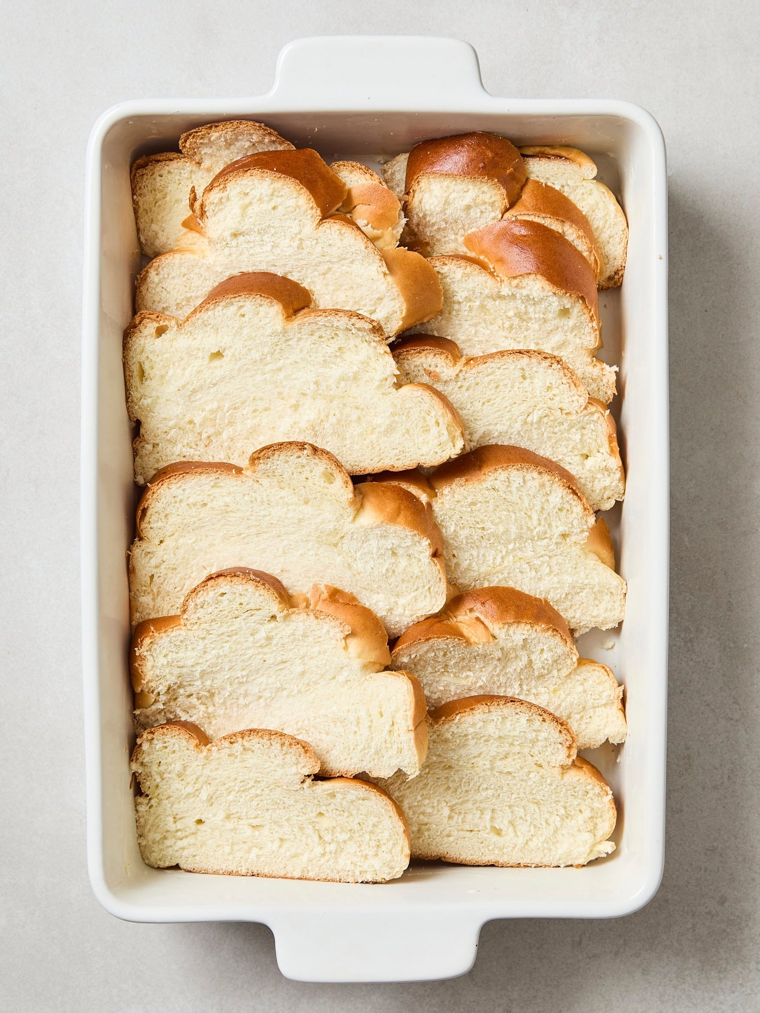 Slices of challah in a baking dish.
