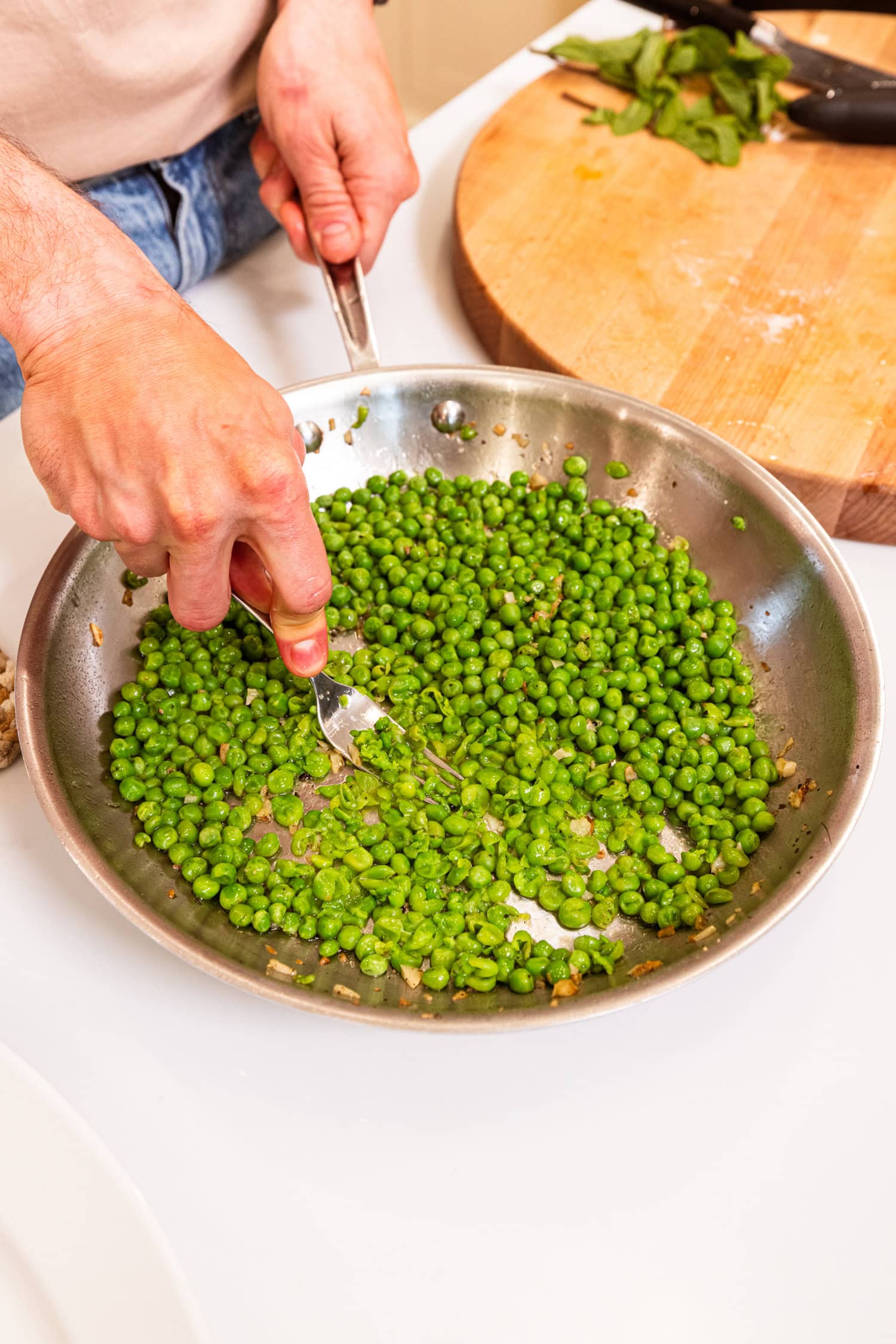 Fork smashing peas for a pea mash.