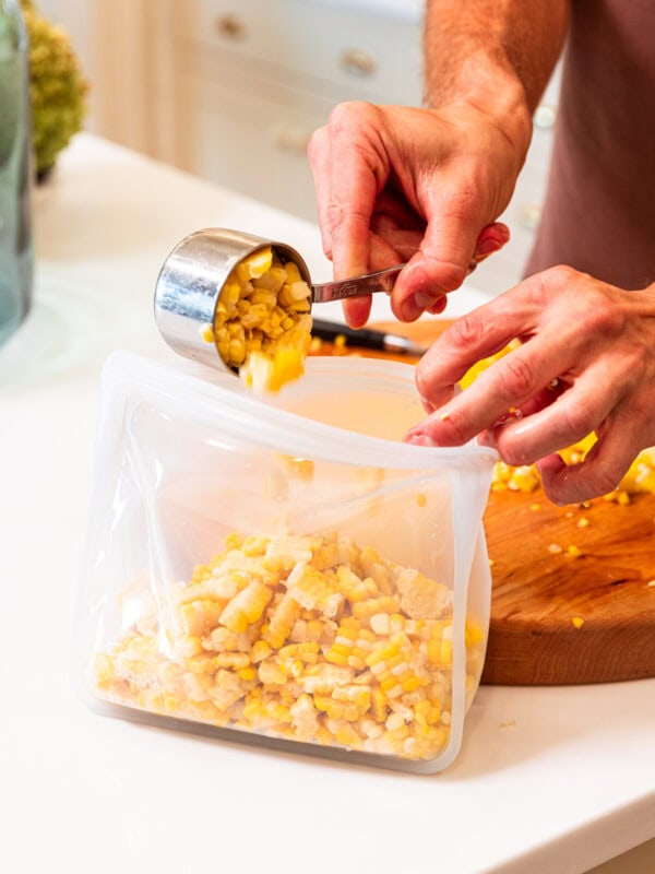 Placing sweet corn into freezer-safe bags.