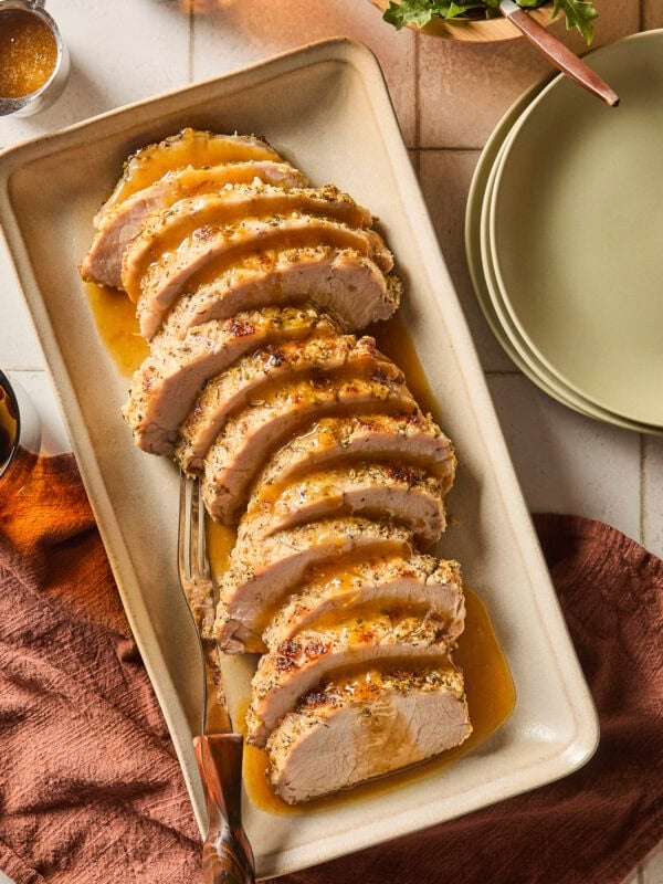 Platter with slices of pork roast with citrus glazed on top.