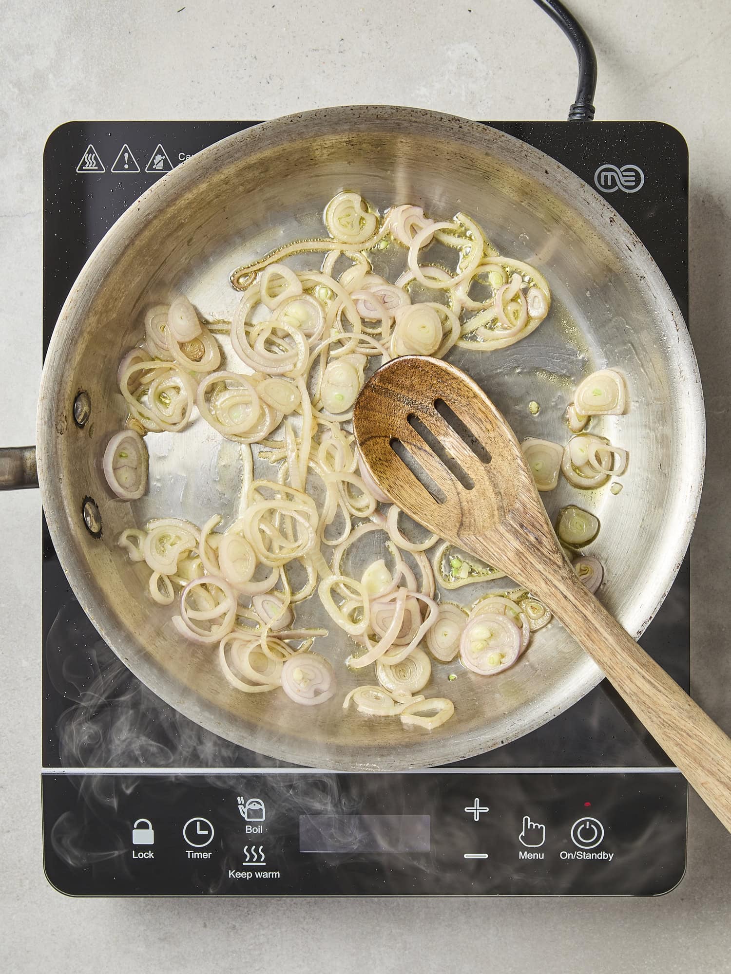 Sliced shallot cooking in skillet.