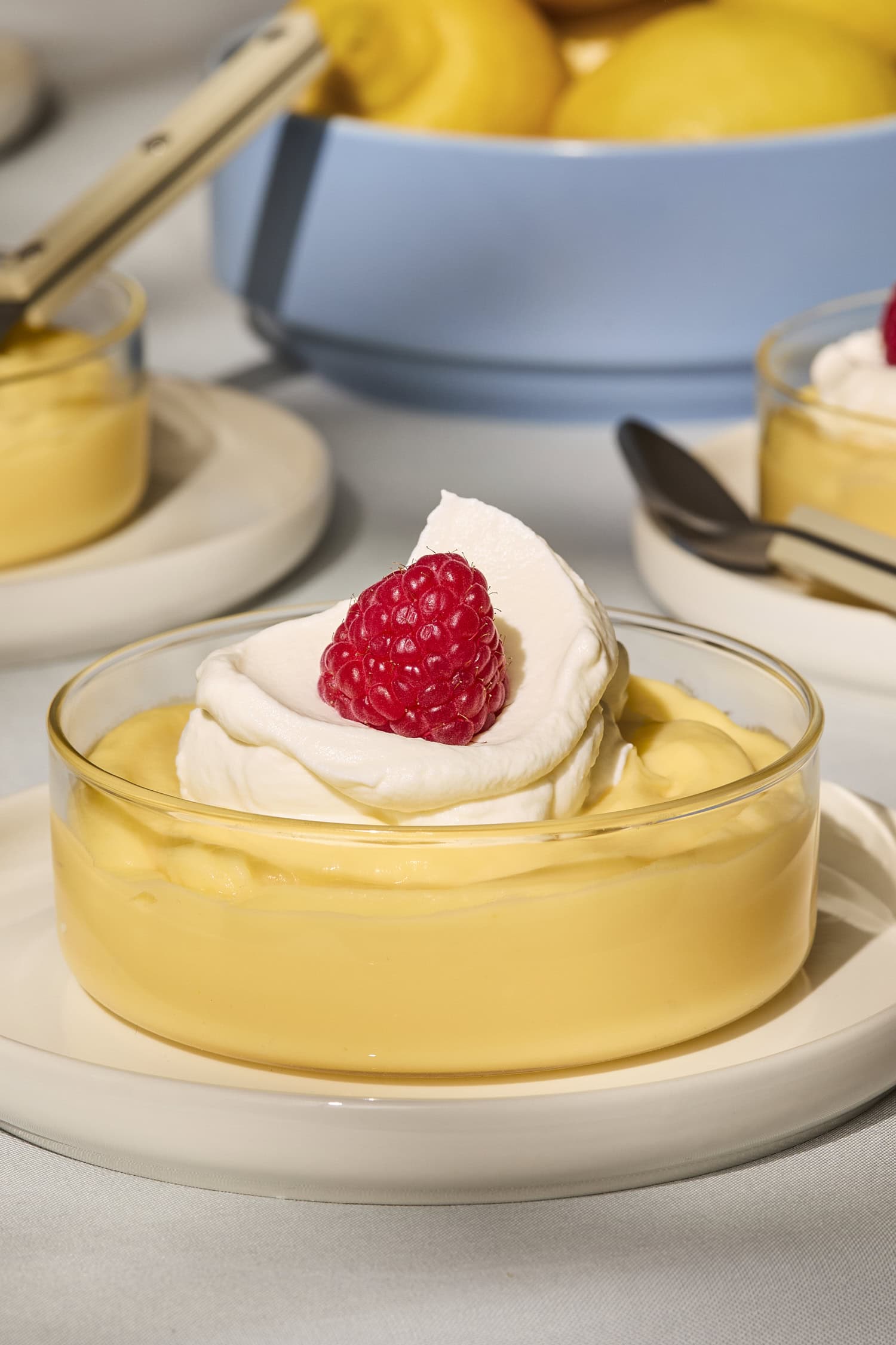 Serving of homemade lemon pudding in a glass with whipped cream on top.