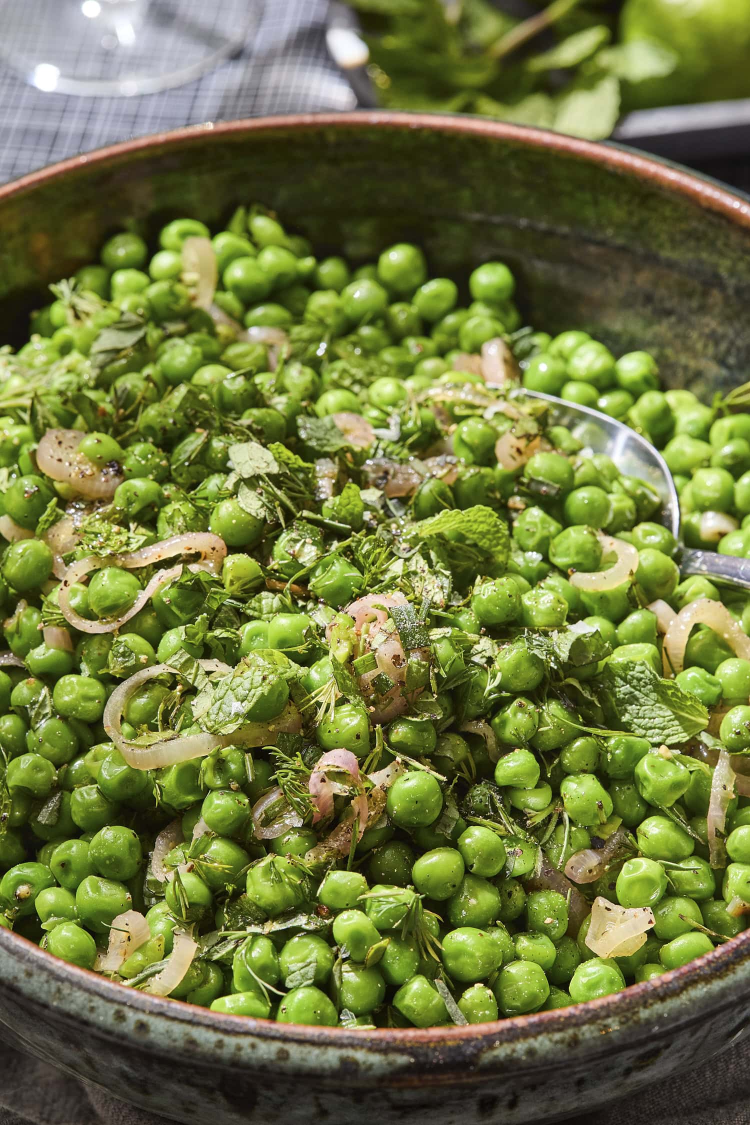 Fresh herbs sprinkled on top of peas with pieces of shallot for side dish.