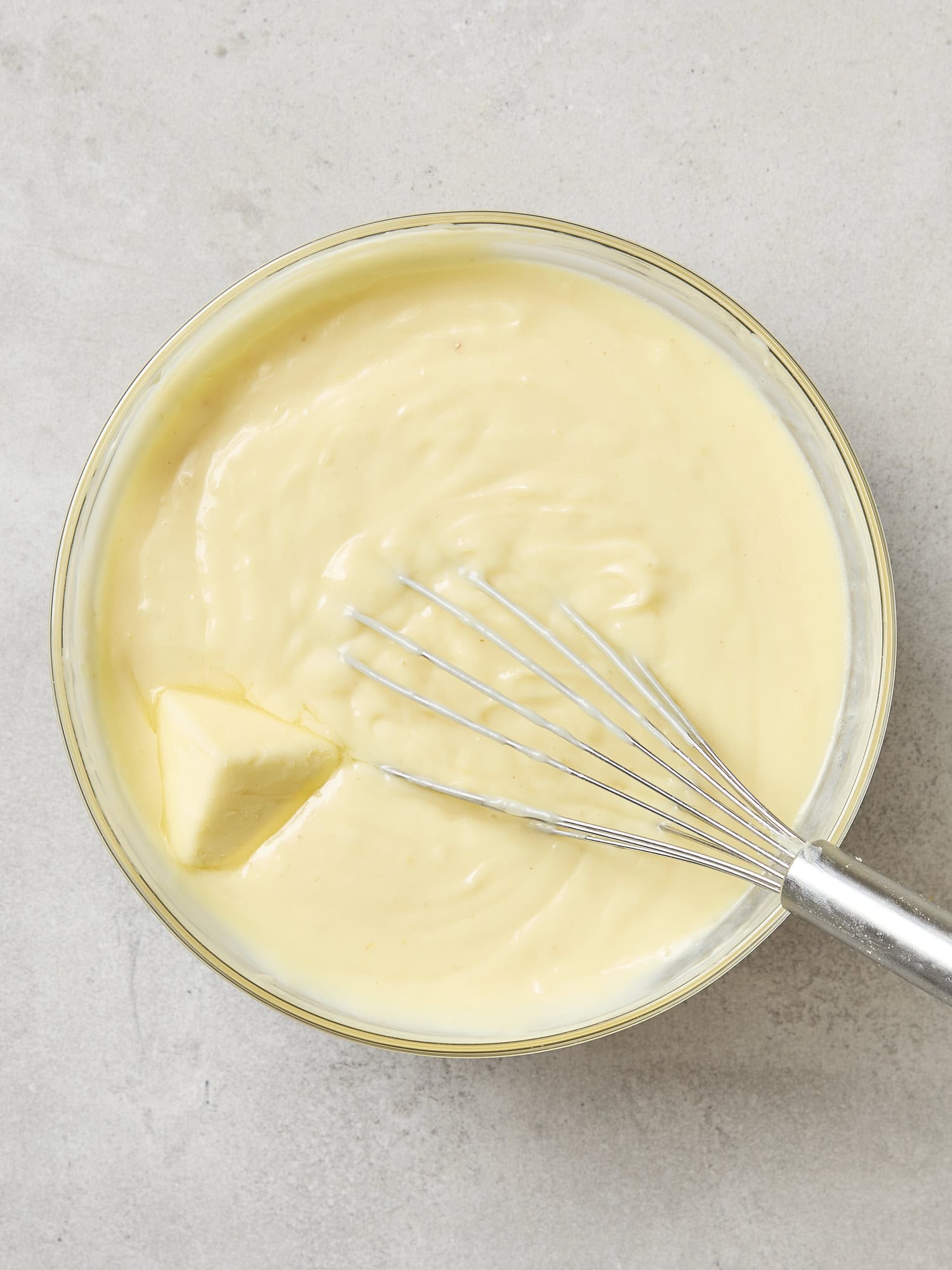 Butter being mixed into lemon pudding.