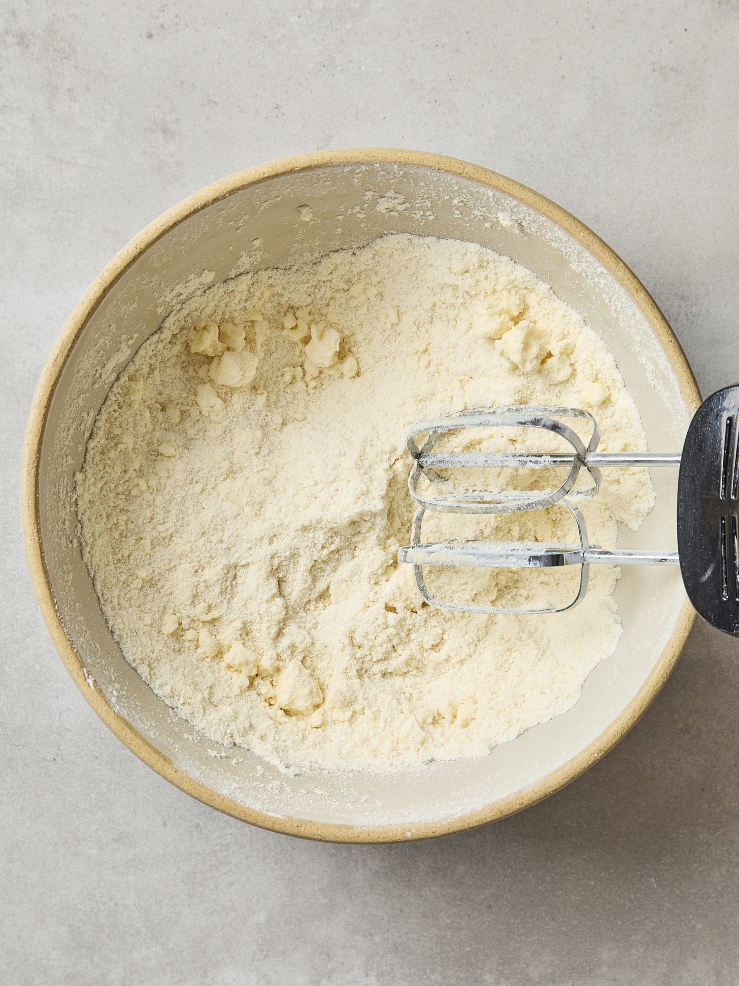 Bowl with dry ingredients mixed together with pieces of butter.