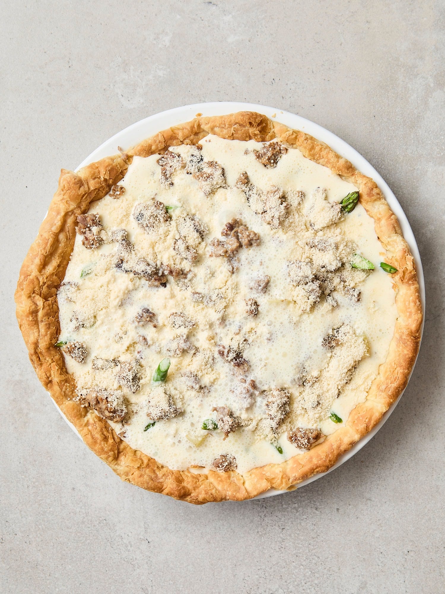 Filled quiche with cream mixture and roasted vegetables.