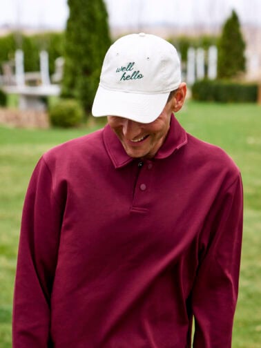 Kaleb wearing white hat with the phrase "well hello".