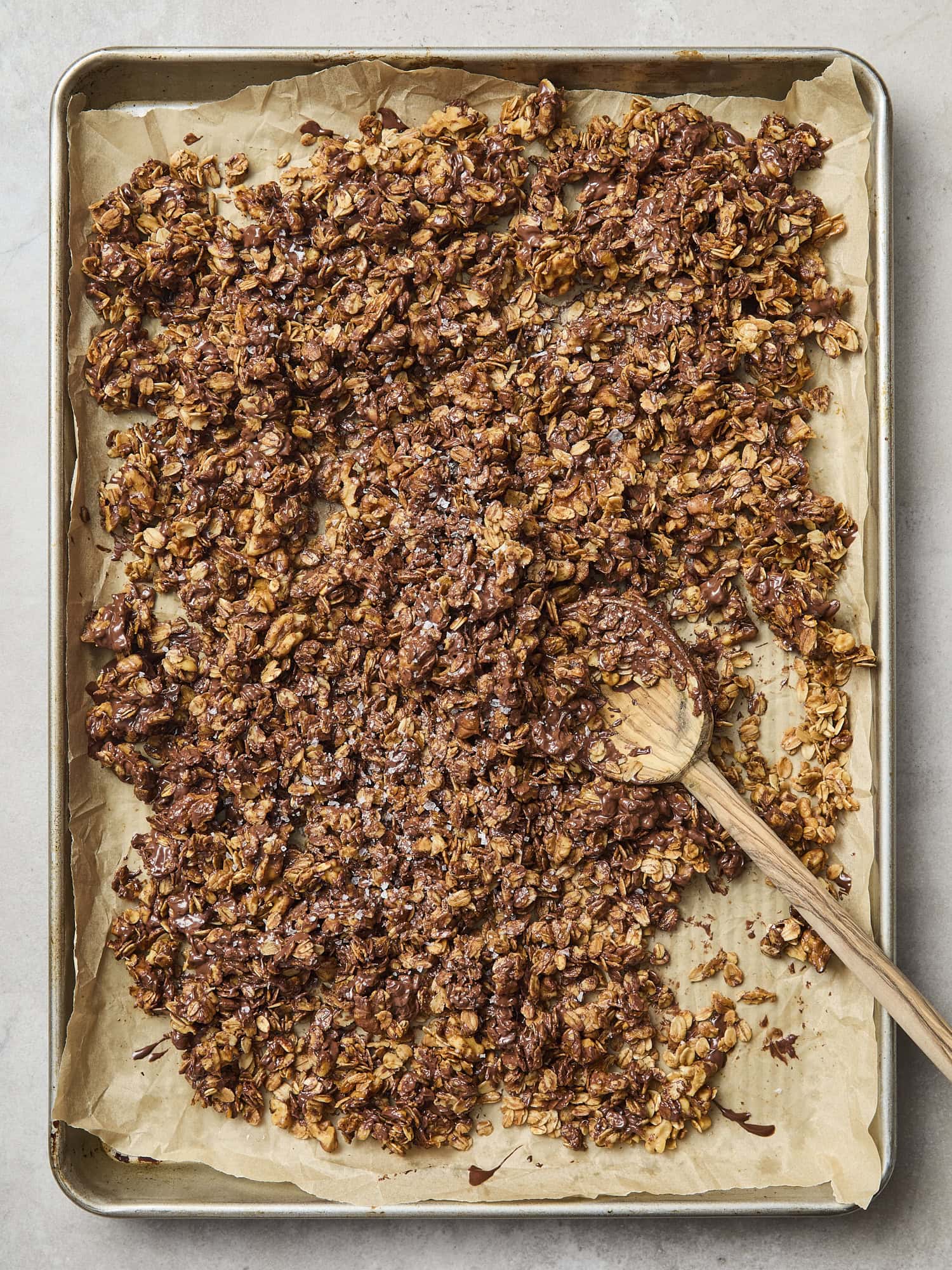 Cooling chocolate chip cookie granola on baking sheet.
