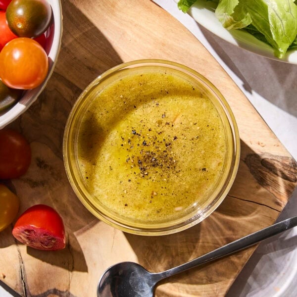 Glass bowl filled with Dijon vinaigrette dressing for salad.
