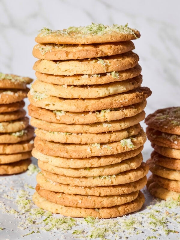 Stack of lime sugar cookies with more zest sprinkled.