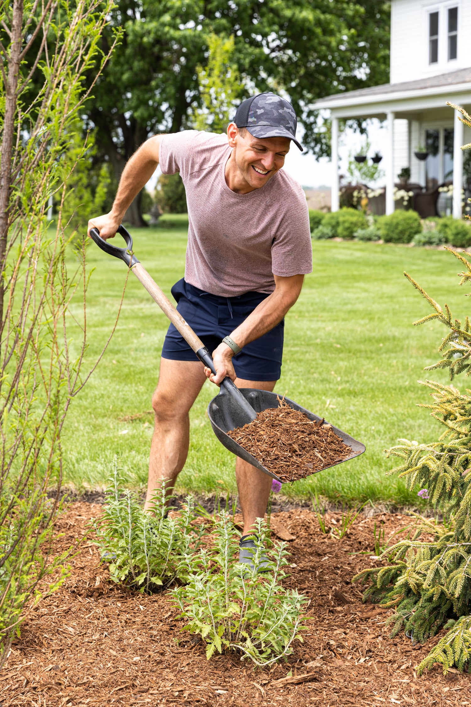 Kaleb holding a shovel filled with mulch.