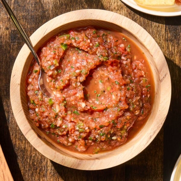 Wooden bowl filled with salsa with spoon.