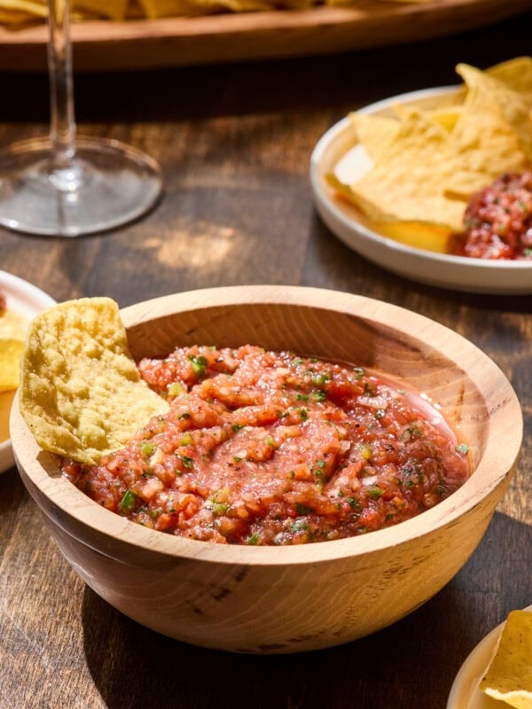 Tortilla chip dipping into restaurant-style salsa.
