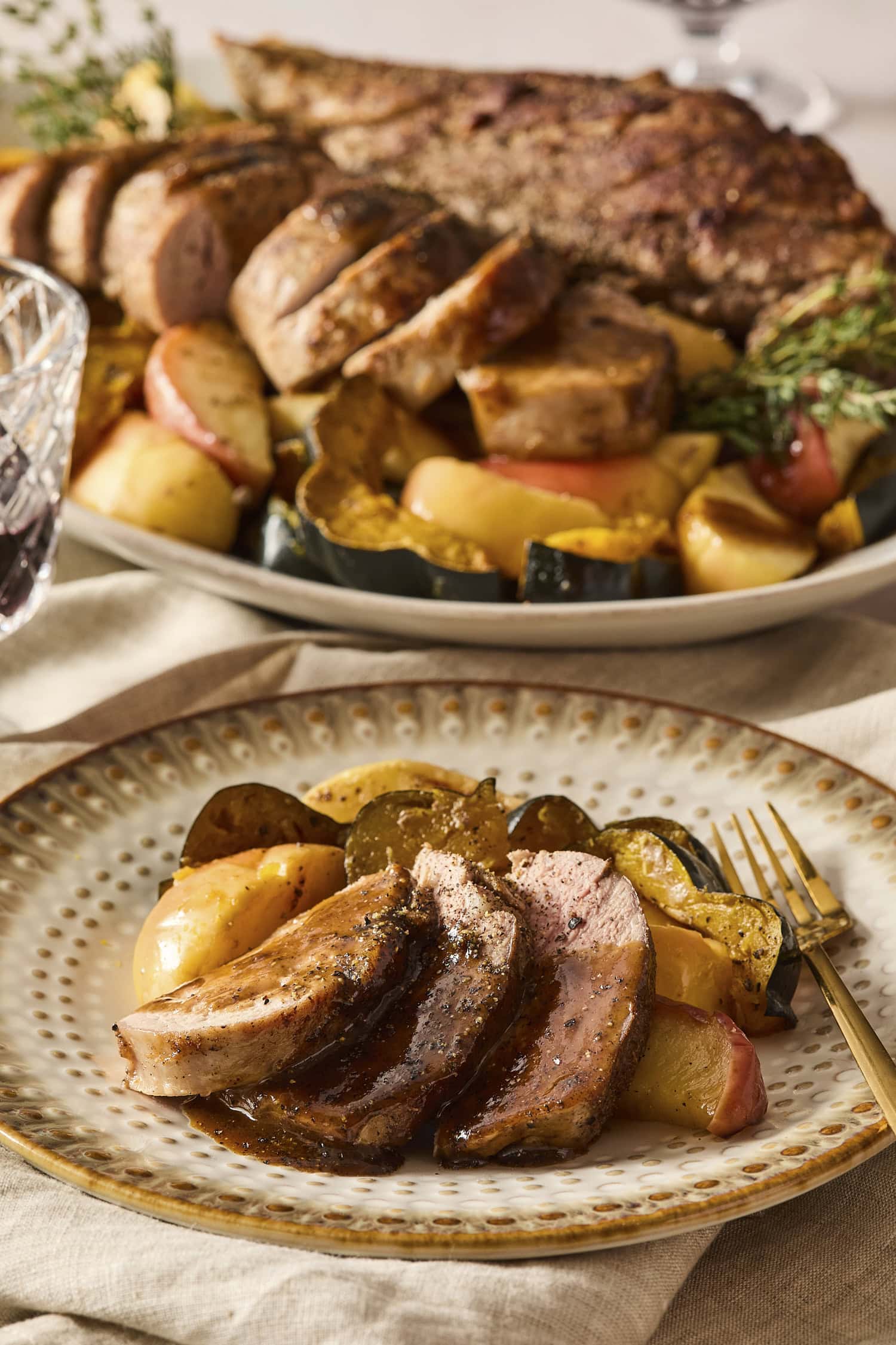 Sliced pork tenderloin with apples on a plate.