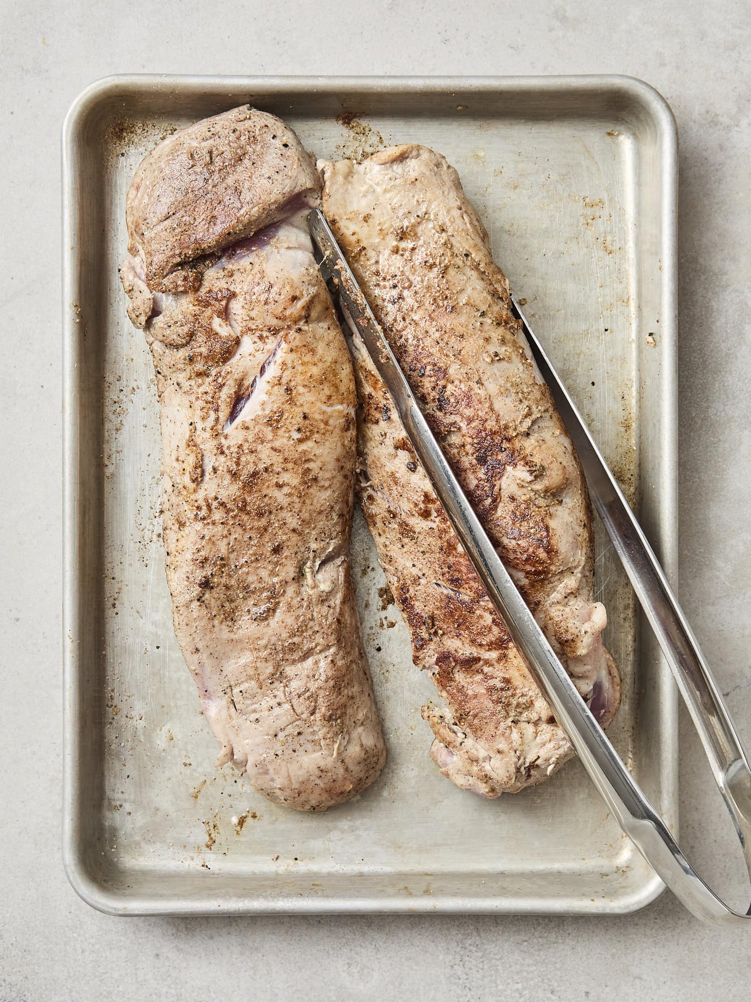 Seared pork tenderloins on baking dish.