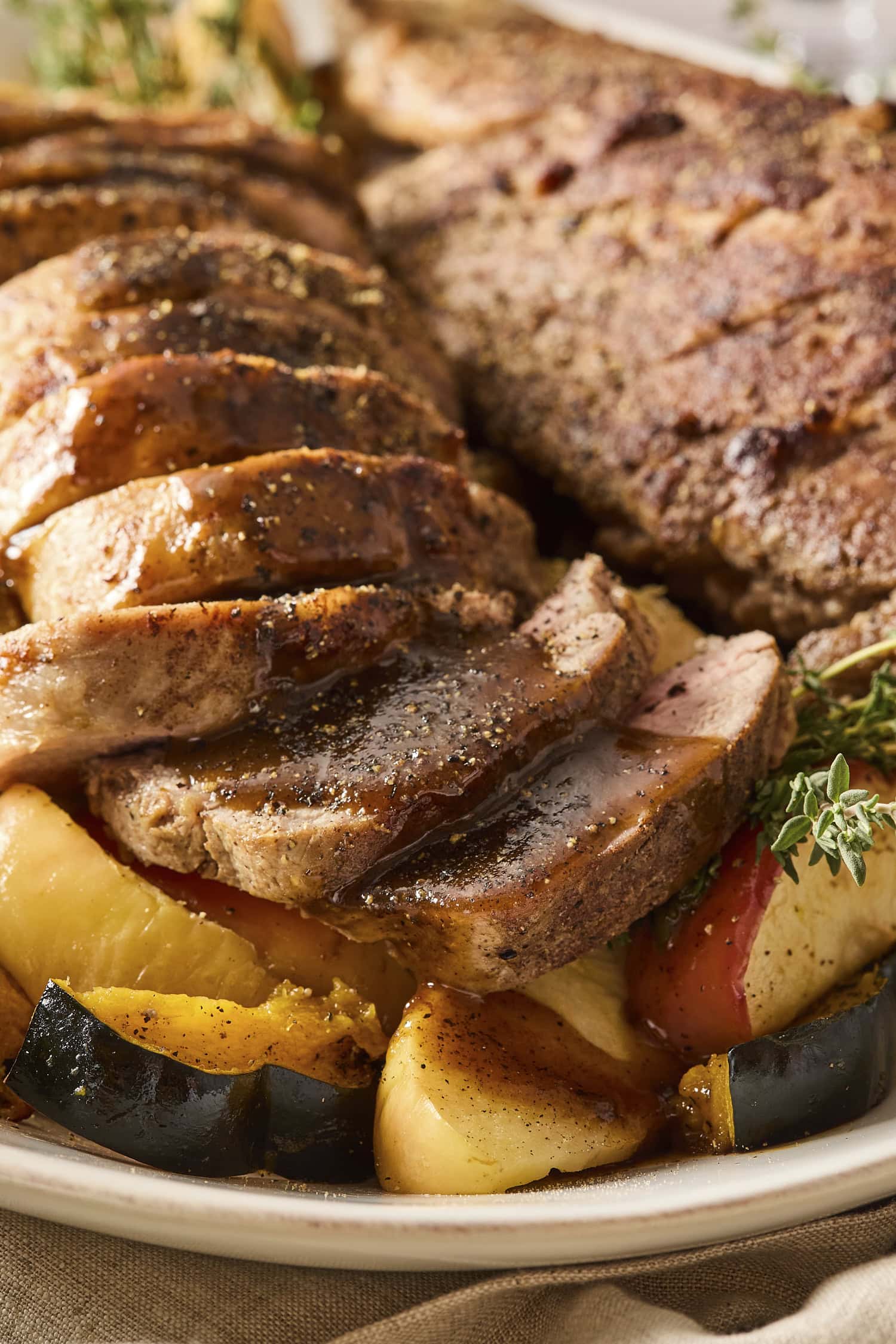 Sliced pork tenderloin with a cider pan sauce on top.