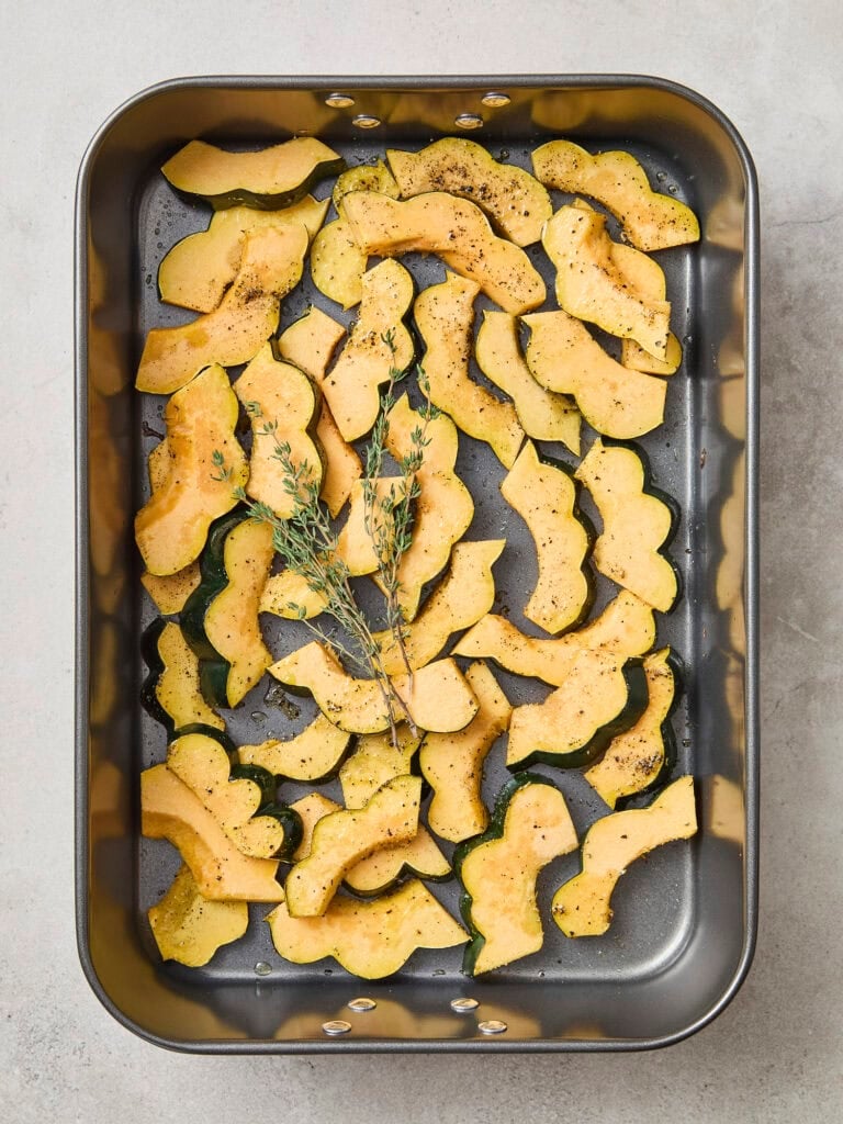 Pan with sliced pieces of squash before roasting.