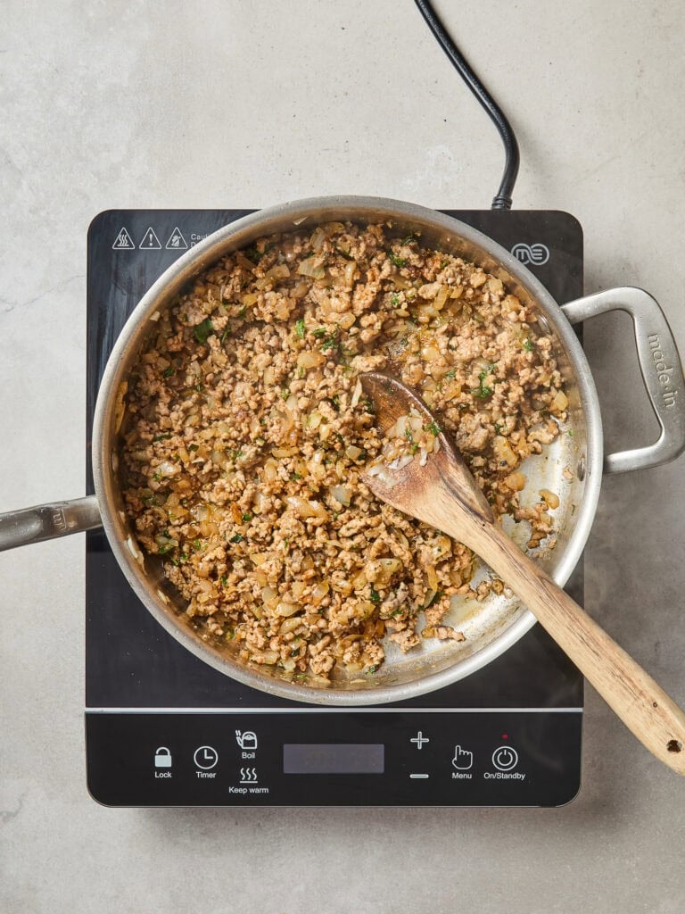 Cooked pork and onion for the base of a cabbage skillet.