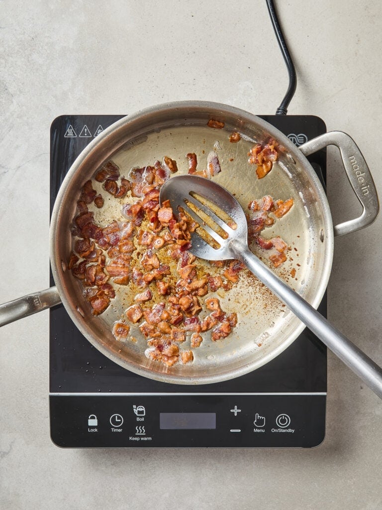 Cooked bacon in the skillet for a cabbage skillet.