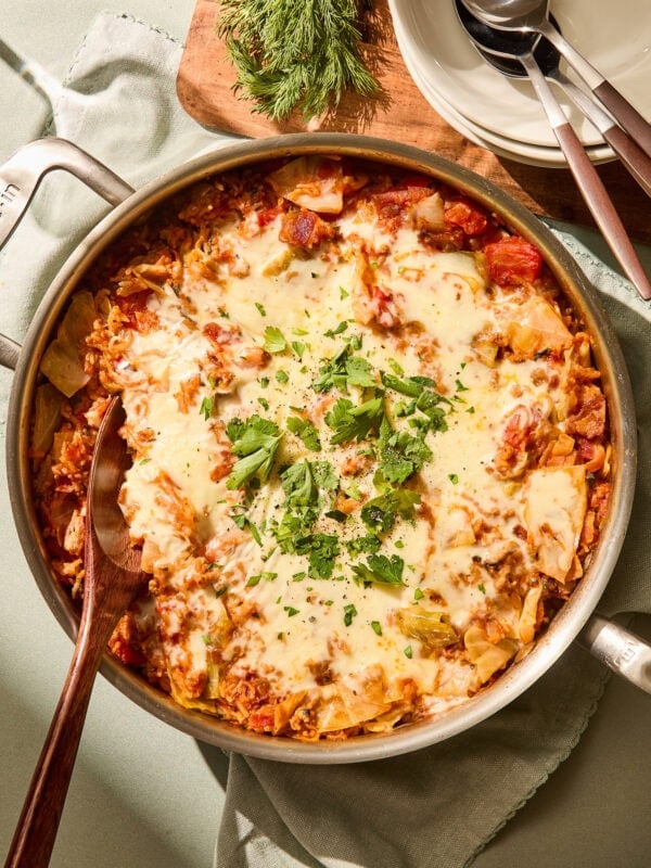 Parsley on top of melted cheese on a cabbage skillet.